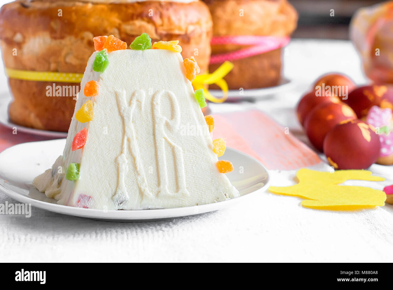 Arrière-plan de l'alimentation de Pâques. Caillé traditionnel gâteau de Pâques avec des fruits confits cookies et Pâques oeufs peints sur la table lumineuse maison de vacances Banque D'Images