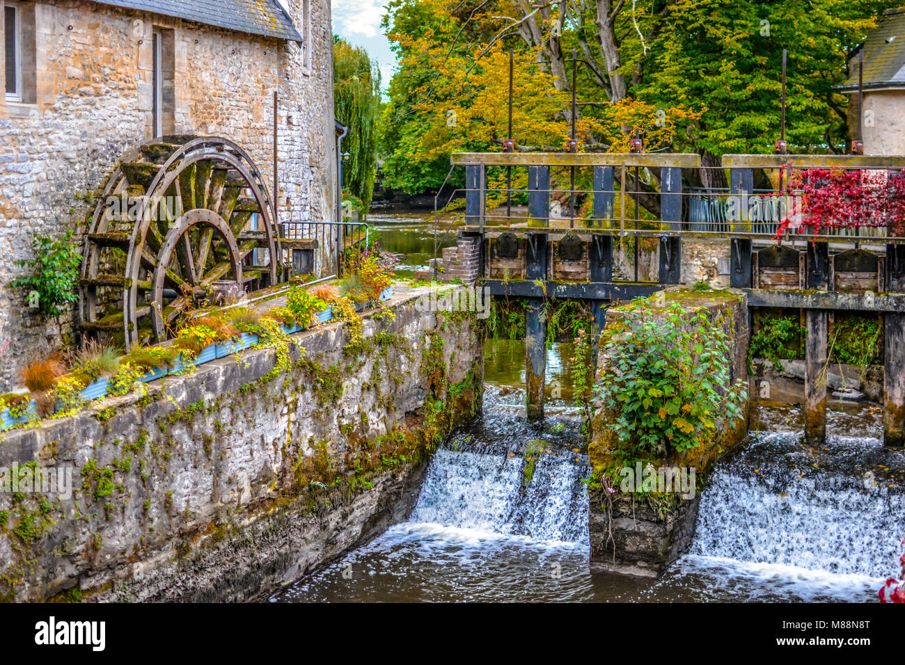 Le moulin à eau sur la rivière Aure dans la ville médiévale de Bayeux en Normandie de la France, avec des couleurs de début d'automne Banque D'Images