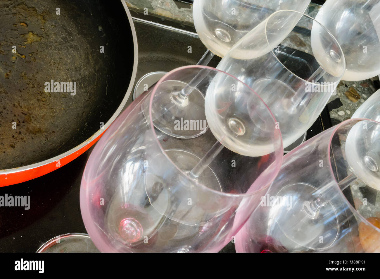 Vide sale verres à vin rouge et d'une pan, après un bon dîner, attendent d'être lavées Banque D'Images