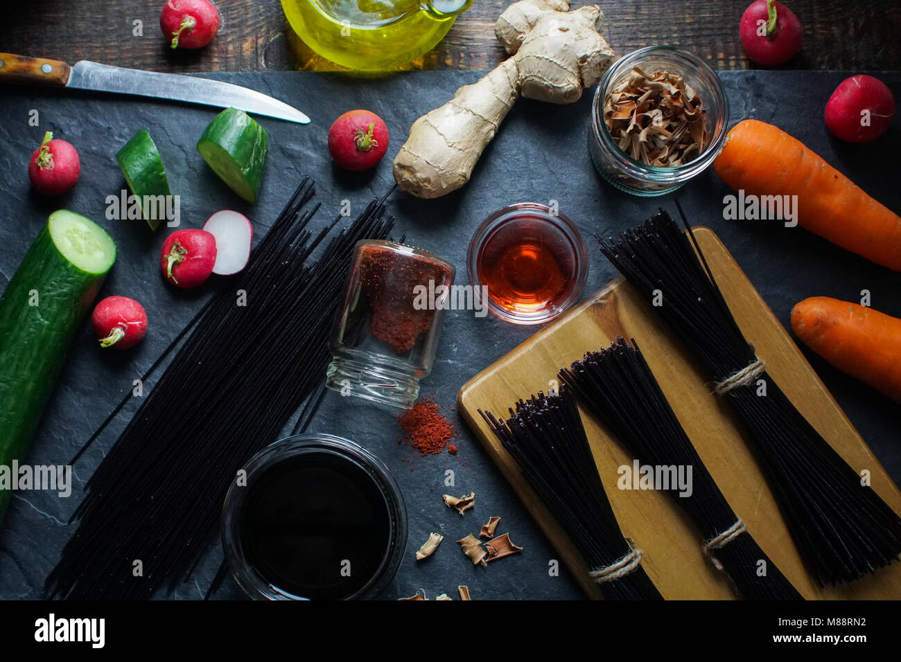 Vermicelles de riz noir, du vinaigre et des légumes sur une ardoise noire Vue de dessus. Horizontale de la cuisine asiatique Banque D'Images