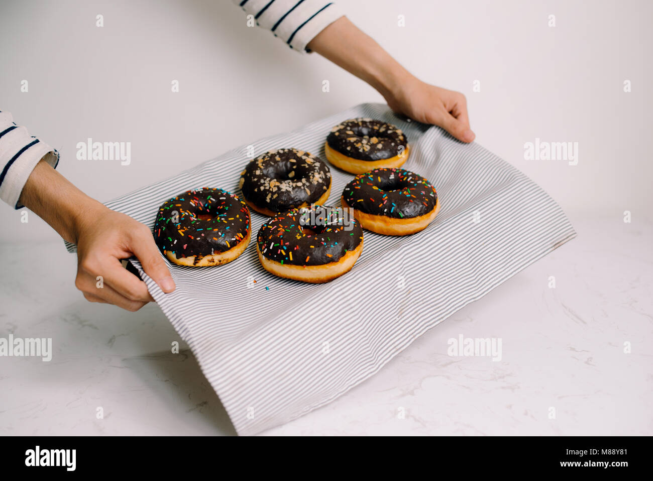 Male hands holding fort avec des beignets au chocolat sur fond blanc Banque D'Images