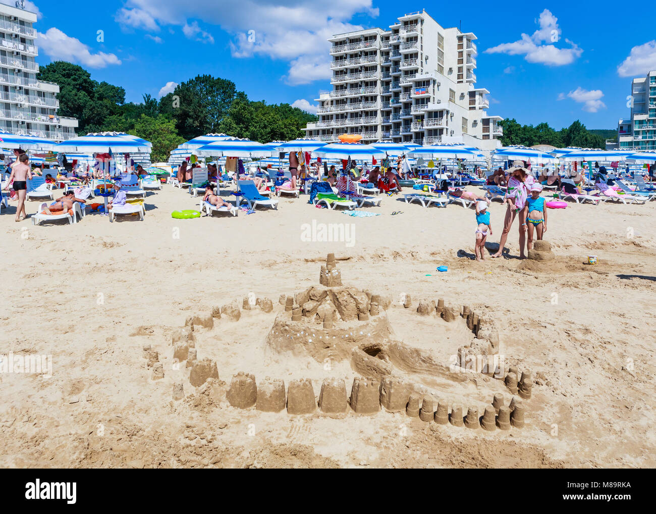 La côte de la mer Noire, le bleu de l'eau claire, avec du sable de plage, parasols et chaises longues. Albena, Bulgarie Banque D'Images