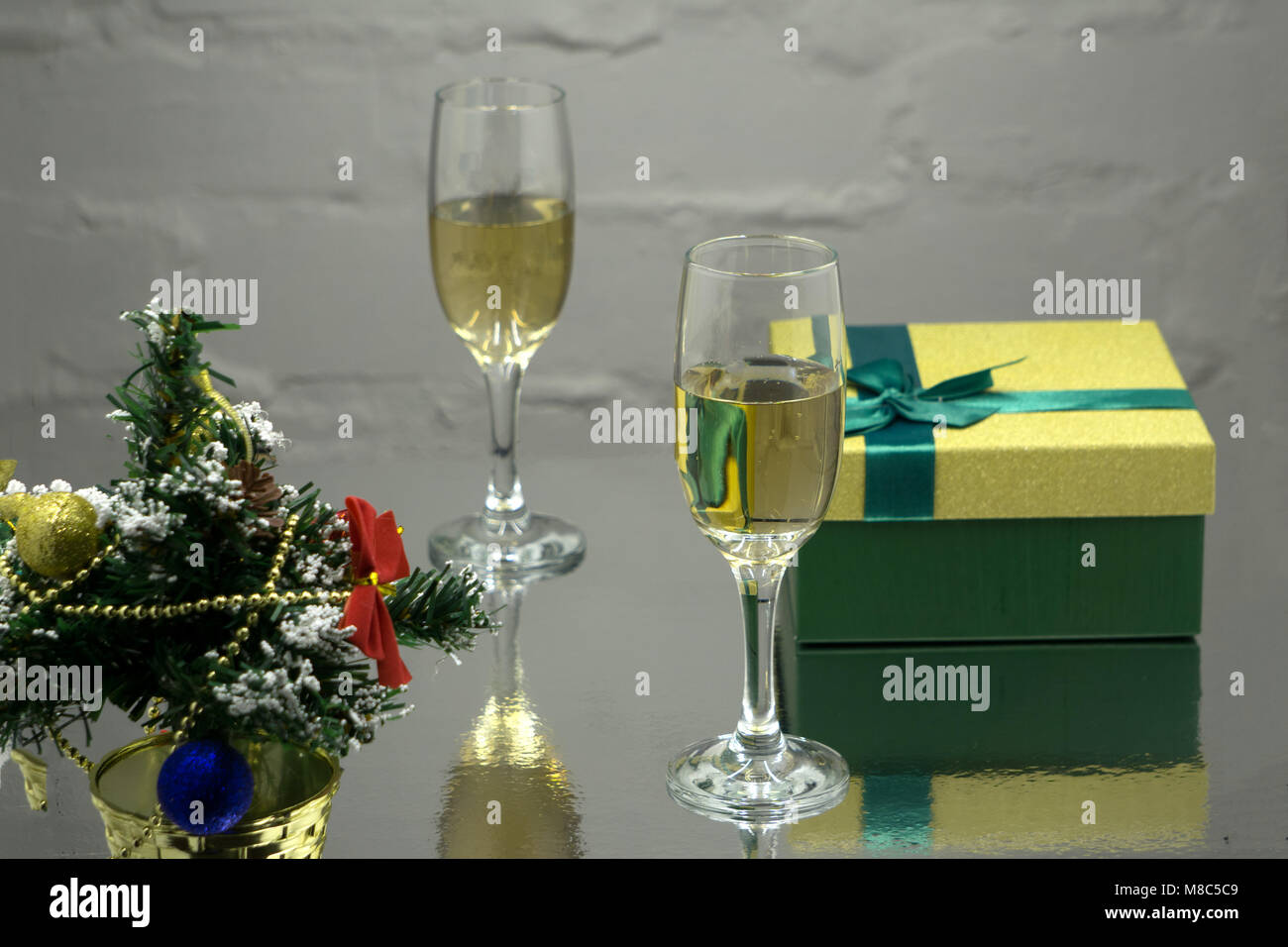 Deux verres avec champange, sapin, avec la direction générale de la décoration, coffrets cadeaux sur un fond noir avec lightes multicolores de Garland. Nouvel an et chri Banque D'Images