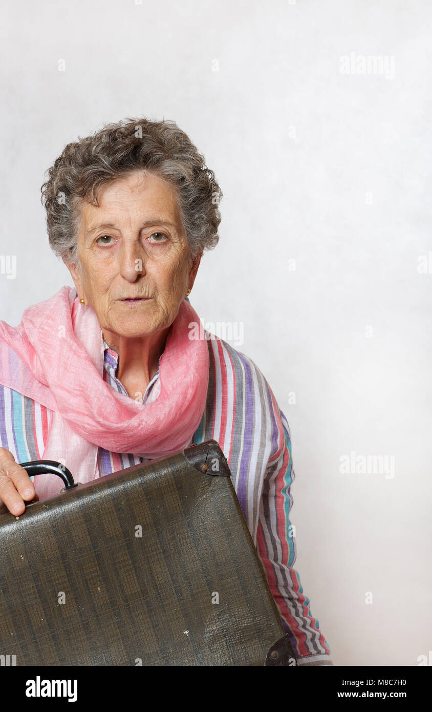 Vieille Femme entre 70 et 80 ans avec l'écharpe rose et vintage suitcase  Photo Stock - Alamy
