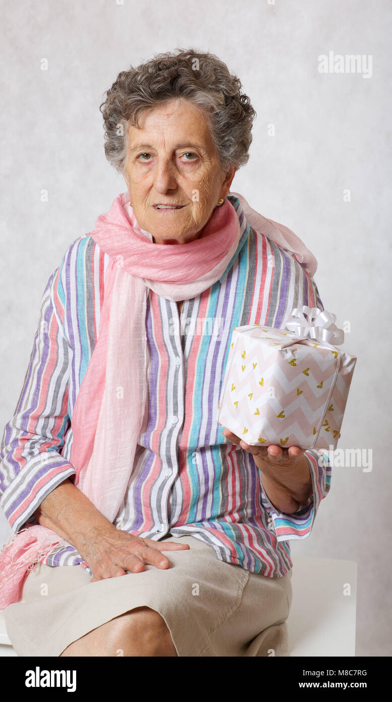Vieille Femme entre 70 et 80 ans en écharpe rose et présent de quelqu'un  Photo Stock - Alamy
