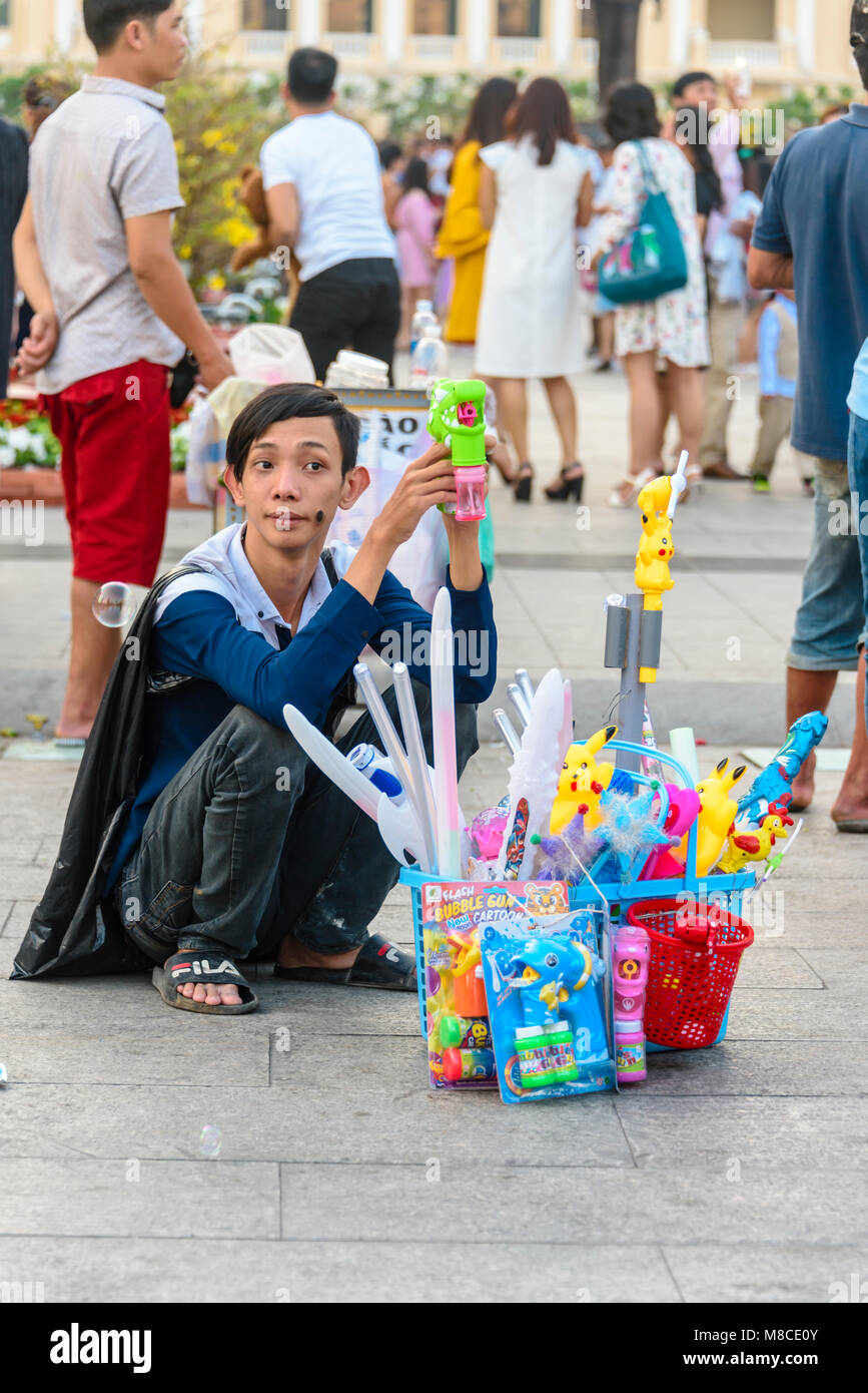 Un vendeur de rue vendant des jouets à bas prix y compris allumé épées, Pokemon et machines à bulles, Ho Chi Minh Ville, Saigon, Vietnam Banque D'Images