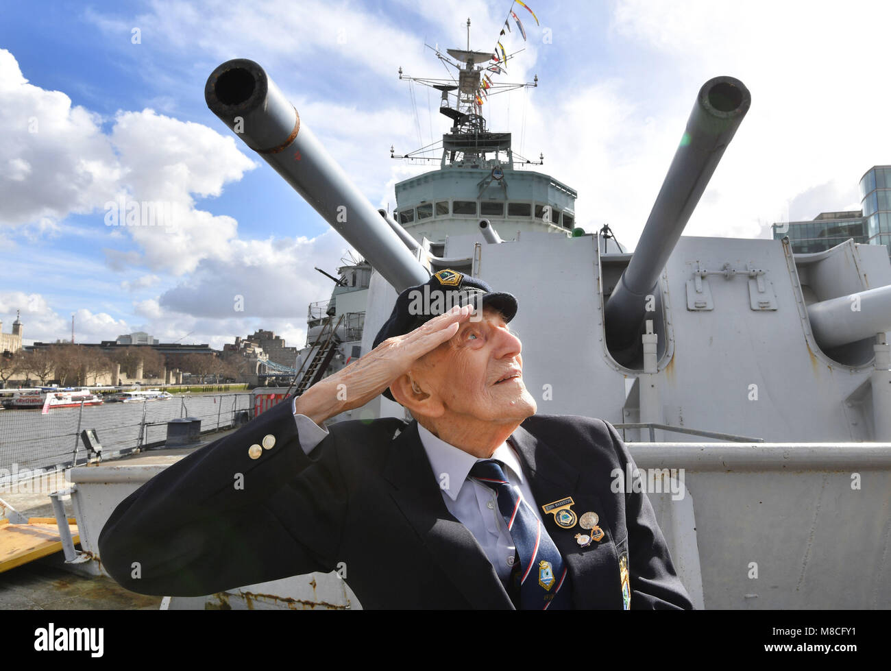 John Harrison âgés de 104, se trouve sur le pont avant du HMS Belfast en face d'une tourelle à canon, qu'il a prescrits pendant la Seconde Guerre mondiale, alors que les anciens combattants qui ont servi sur le navire de guerre dans les années 1940, 1950 et 1960 répondre à bord du bateau historique sur la Tamise à Londres pour marquer son 80e anniversaire. Banque D'Images