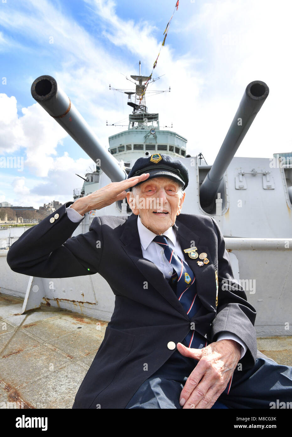 John Harrison âgés de 104, se trouve sur le pont avant du HMS Belfast en face d'une tourelle à canon, qu'il a prescrits pendant la Seconde Guerre mondiale, alors que les anciens combattants qui ont servi sur le navire de guerre dans les années 1940, 1950 et 1960 répondre à bord du bateau historique sur la Tamise à Londres pour marquer son 80e anniversaire. Banque D'Images