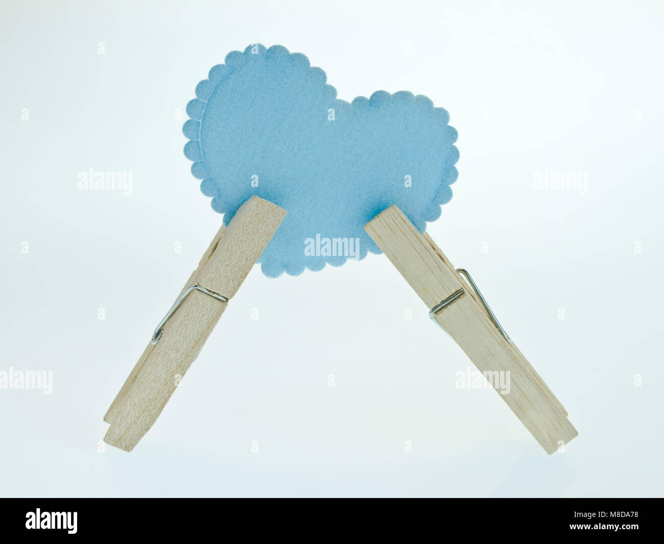 Avec un coeur bleu clothespin sur fond blanc Banque D'Images