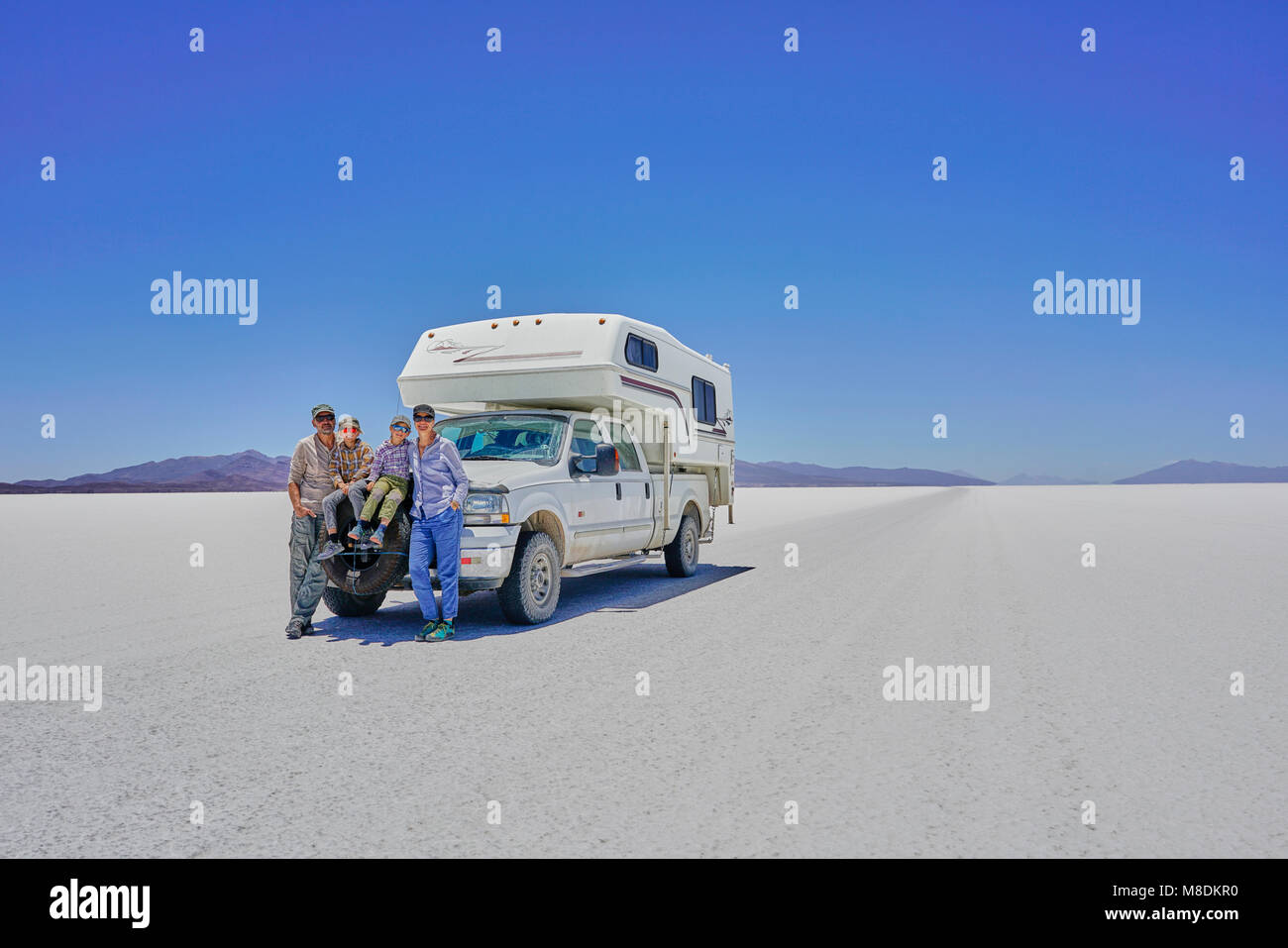 Portrait de famille, debout devant des véhicules récréatifs en stationnement, Salar de Uyuni, Uyuni, Oruro, Bolivie, Amérique du Sud Banque D'Images
