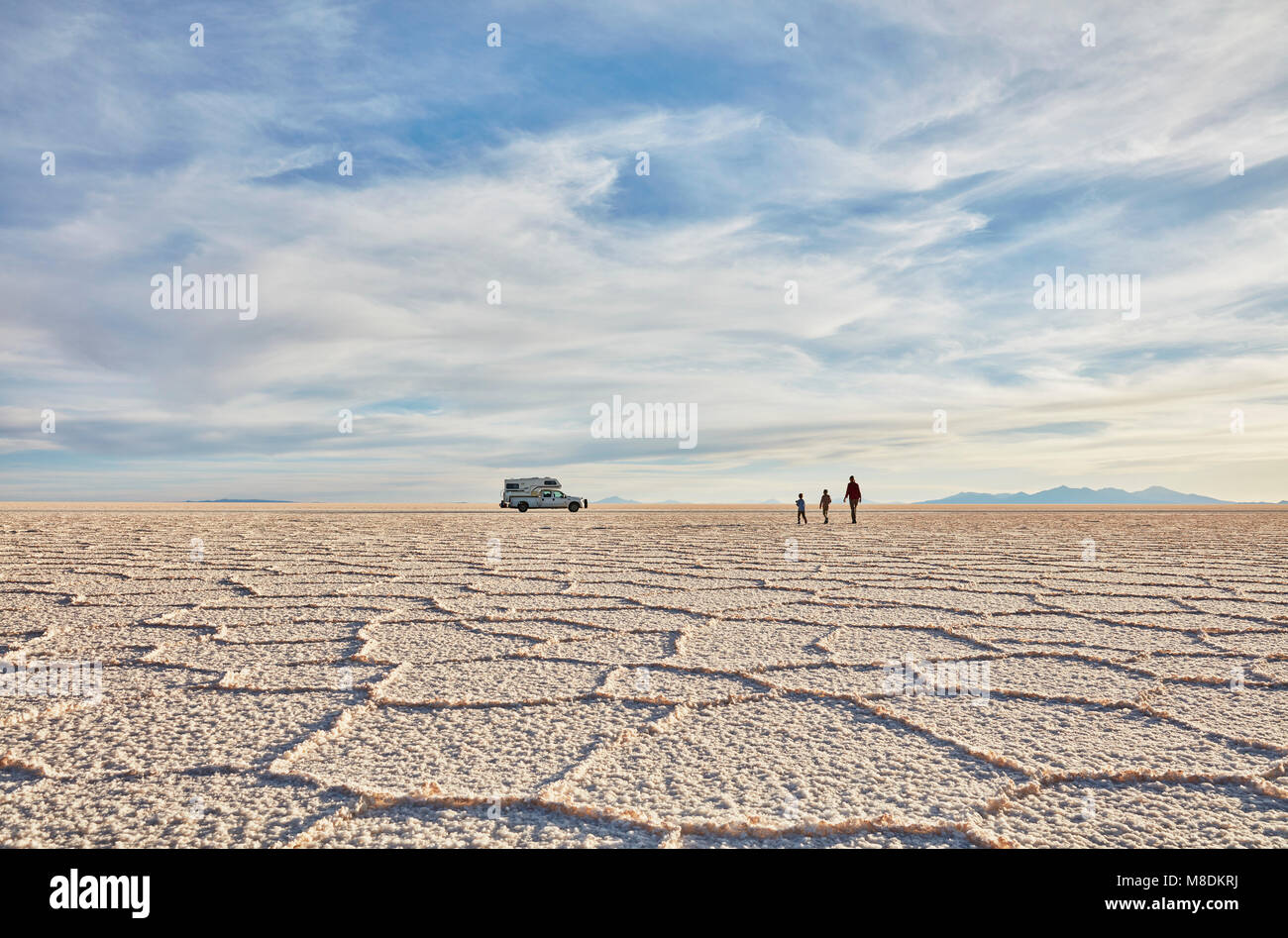 Mère et fils de marcher à travers les plaines salines, véhicule récréatif en arrière-plan, Salar de Uyuni, Bolivie Banque D'Images