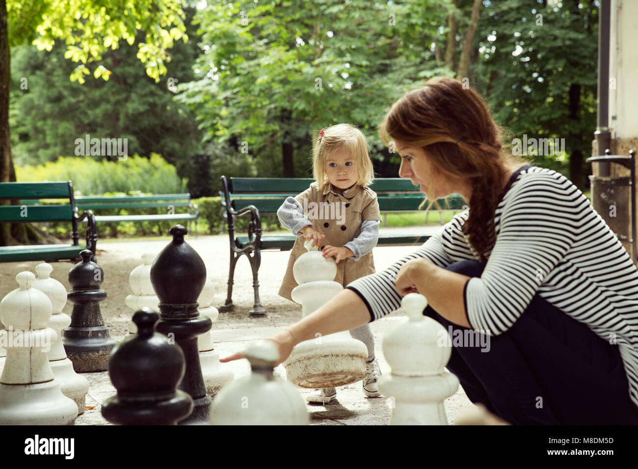 Mère et fille enfant jouant avec un échiquier géant dans le parc Banque D'Images