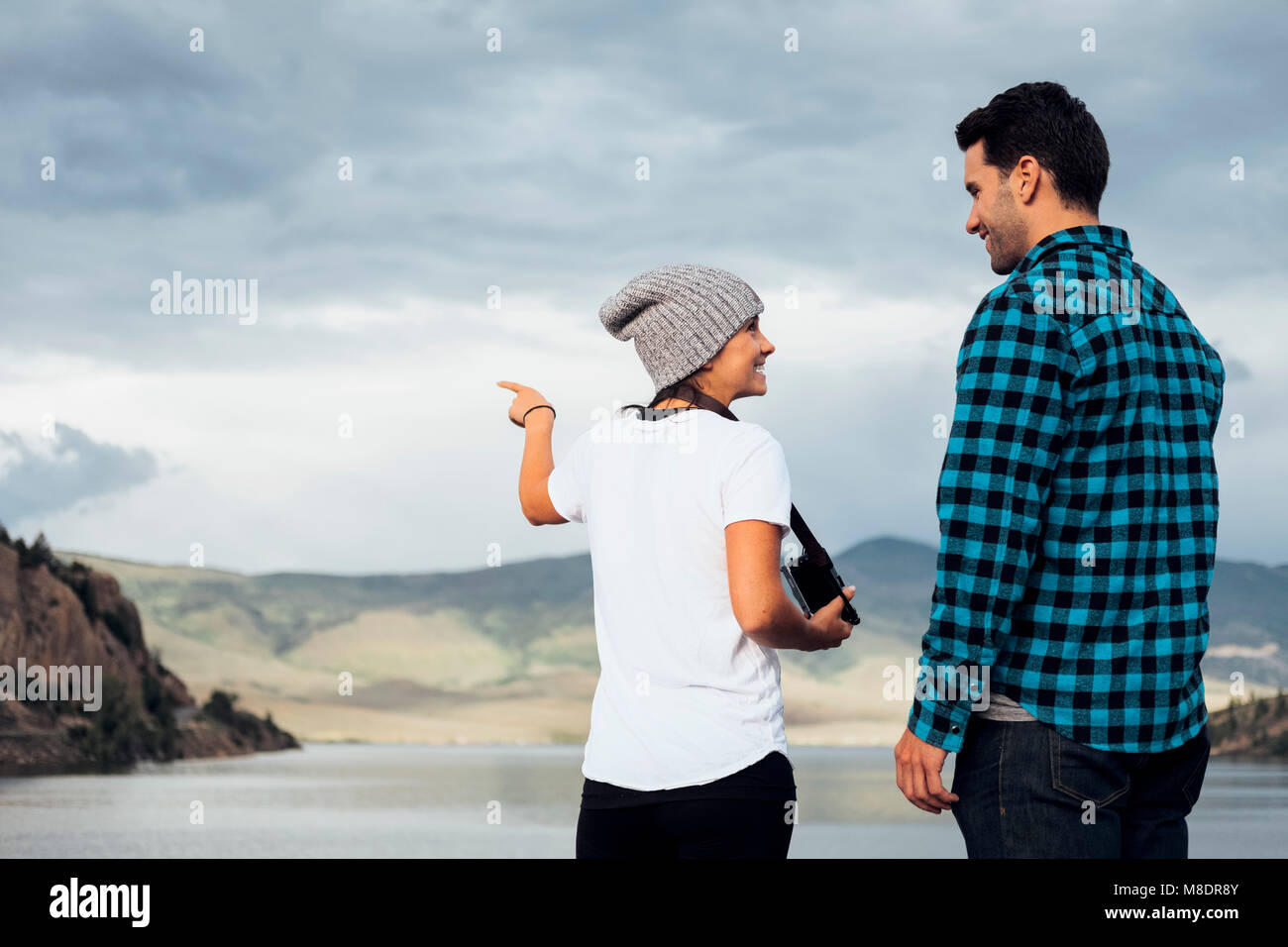 Couple debout sur mur près de Dillon Reservoir, looking at view, Silverthorne, Colorado, USA Banque D'Images