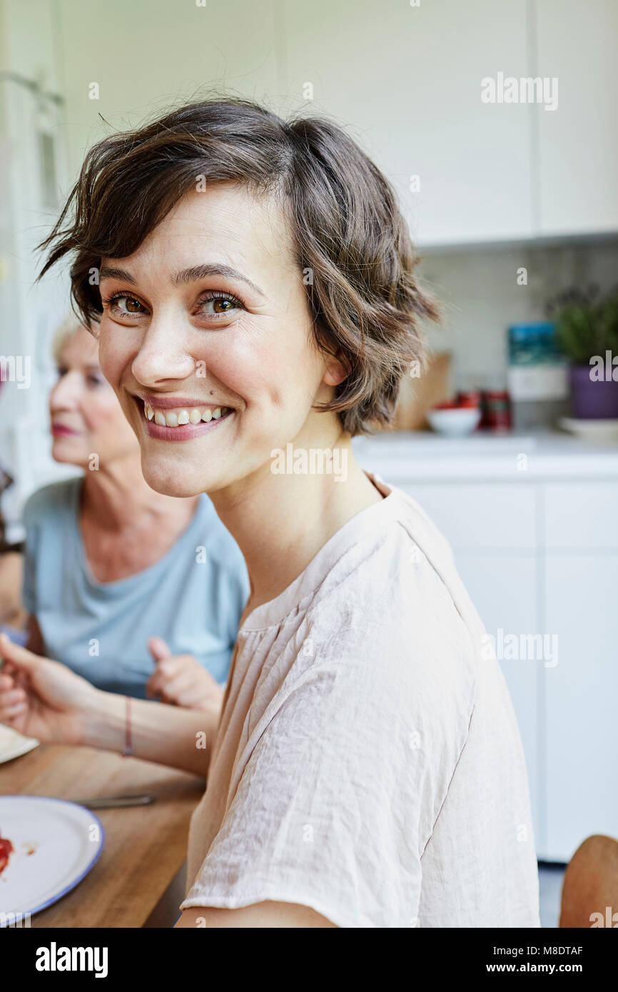 Portrait of mid adult woman at dinner table, smiling Banque D'Images