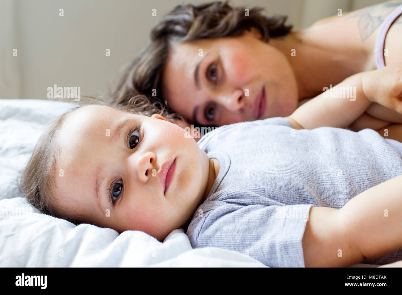 Portrait de Mère et fille de bébé, détente sur lit Banque D'Images