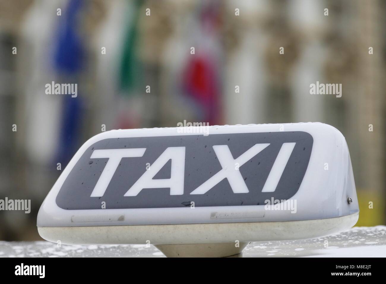Taxi stationné en lignes clients en attente près de signer sur le toit de voitures Banque D'Images
