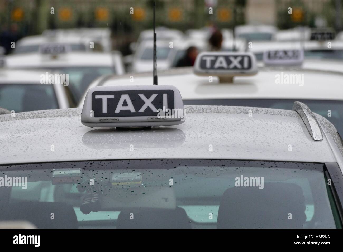 Taxi stationné en lignes clients en attente près de signer sur le toit de voitures Banque D'Images