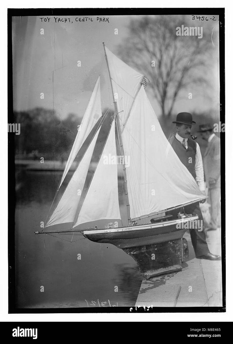 Photographie d'un yacht jouet à Central Park, capturant le bateau miniature naviguant dans les eaux du parc. L'image met en évidence les activités de loisirs et de détente qui ont lieu dans l'un des espaces verts les plus célèbres de New York. Banque D'Images
