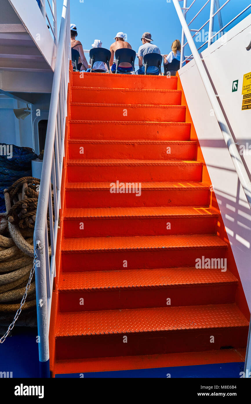 Escalier métallique orange vif à l'intérieur d'un ferry pour passagers avec un pont bleu Banque D'Images