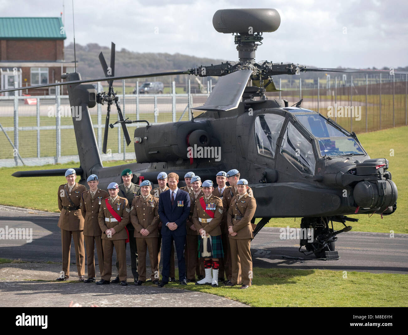 Le prince Harry (première rangée, 2ème à droite) pose pour une photo en face d'un hélicoptère Apache à l'Army Aviation Centre en milieu Wallop, Hampshire, où il a entrepris la formation hélicoptère avancé, afin de présenter les plus récents diplômés avec leurs ailes. Banque D'Images