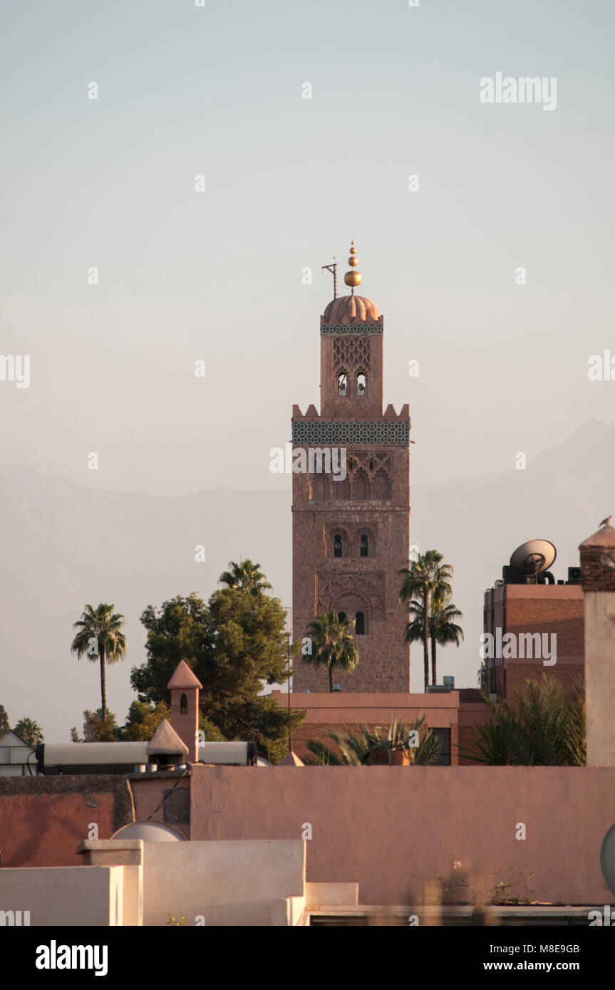 Minaret de la mosquée Koutoubia et les toits de Marrakech Medina contre une vague toile de fond les montagnes de l'Atlas. Copier la mise en page de l'espace. Banque D'Images