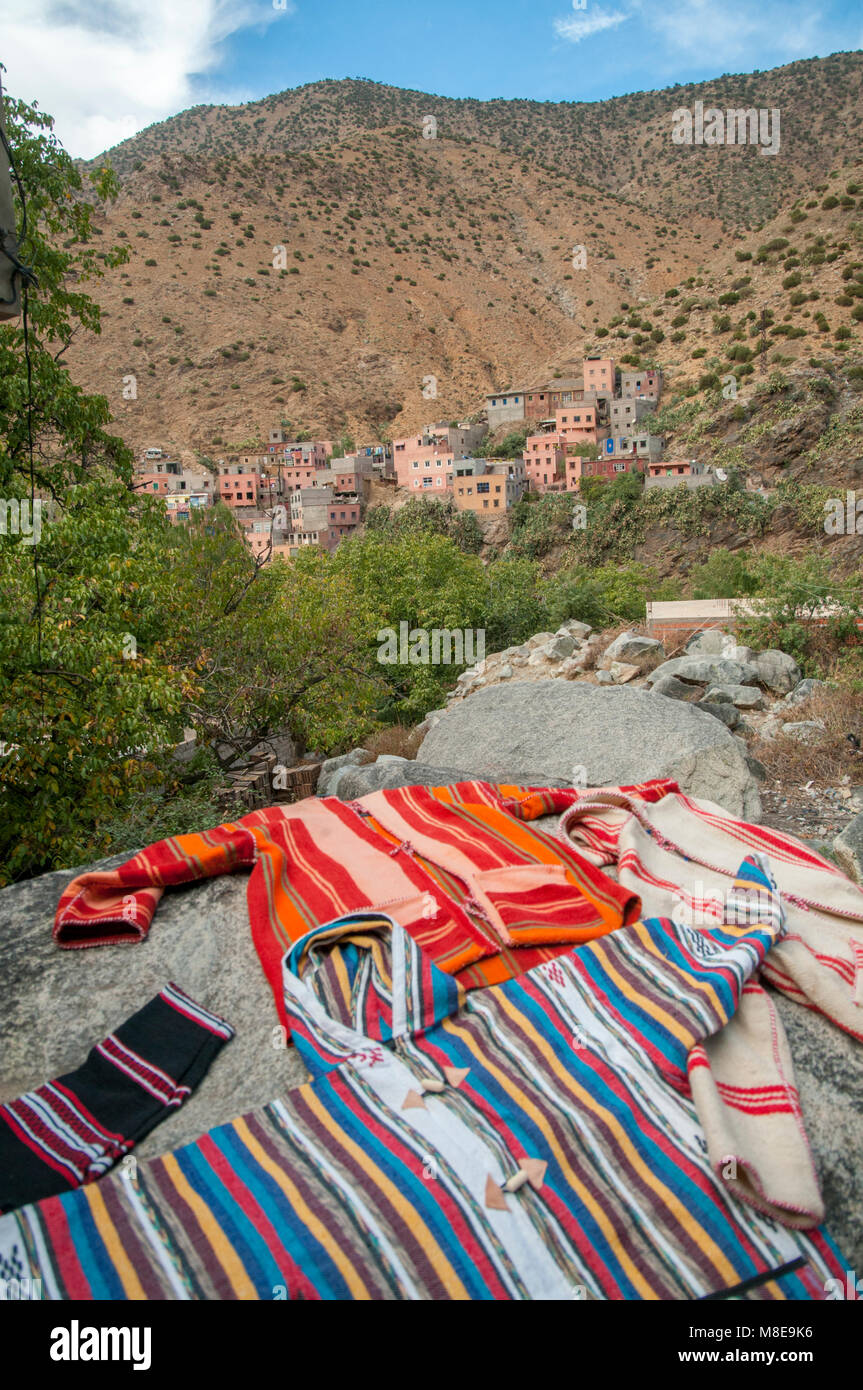 Faits à la main localement colorés vêtements sur l'écran près du village de Setti-Fatma dans les montagnes de l'Atlas, au Maroc. Banque D'Images