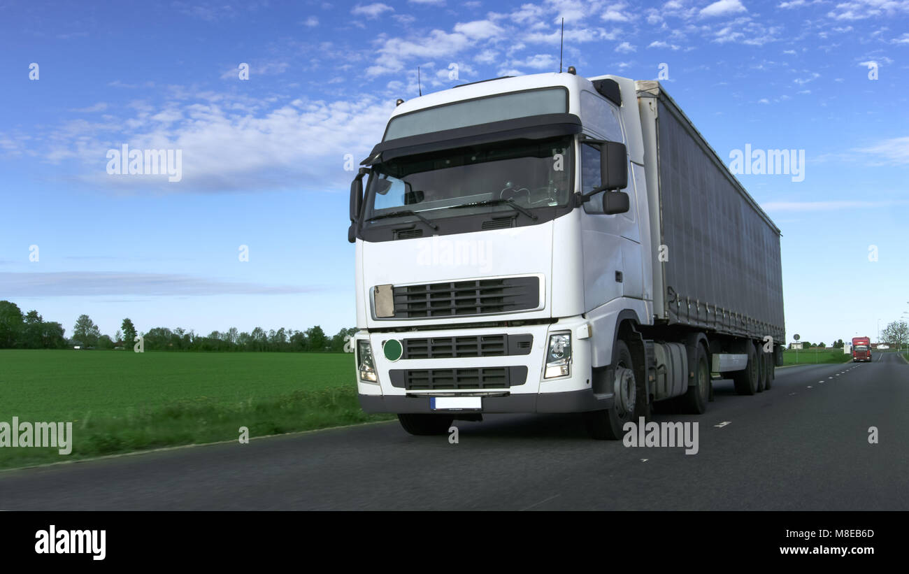 Camion blanc avec Semi-remorque roulant sur la route rurale. Banque D'Images