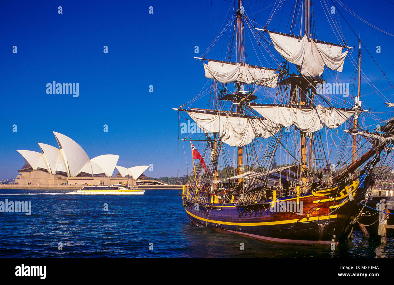 Le HMS Bounty replica navire amarré sur le Campbell's Cove jetty sur le port de Sydney à Sydney, Australie. Le célèbre Opéra de Sydney peut être vu dans l'arrière-plan. Banque D'Images