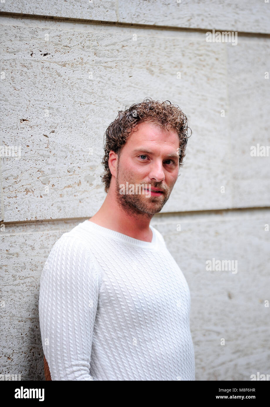 Bel homme debout contre un mur Banque D'Images