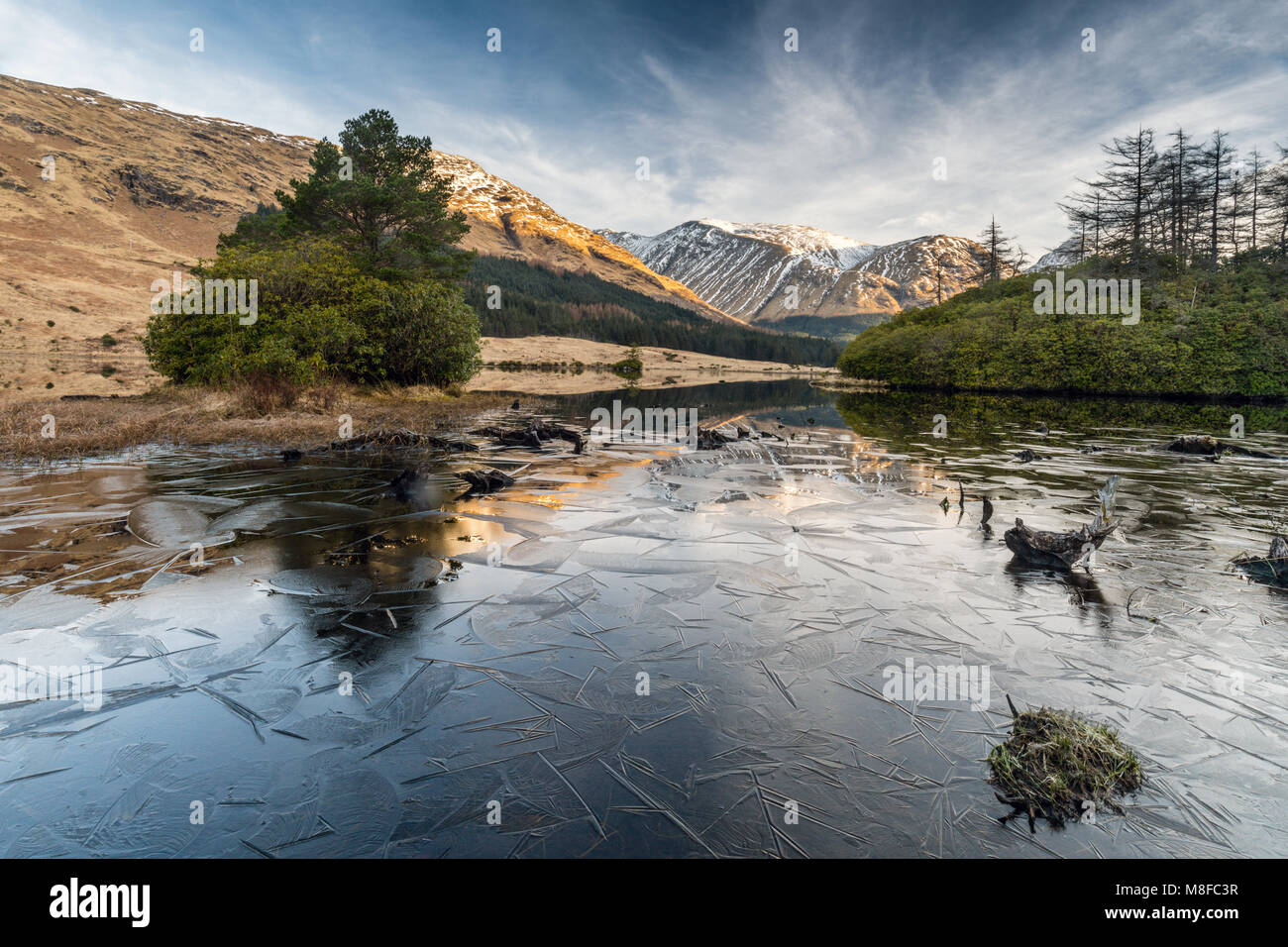 Réflexions à Lochan Urr sur une froide journée de printemps ensoleillée claire, Glen Etive, Highlands, Ecosse, Royaume-Uni Banque D'Images