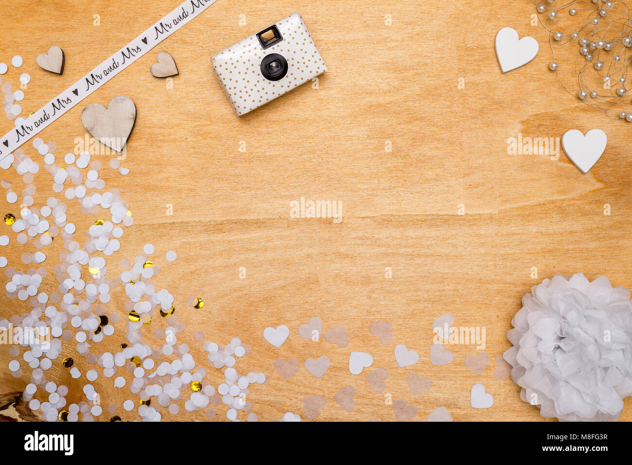 Décoration de mariage pour partie en blanc et or et confettis coeurs en bois couché sur fond de bois comme flatlay Banque D'Images