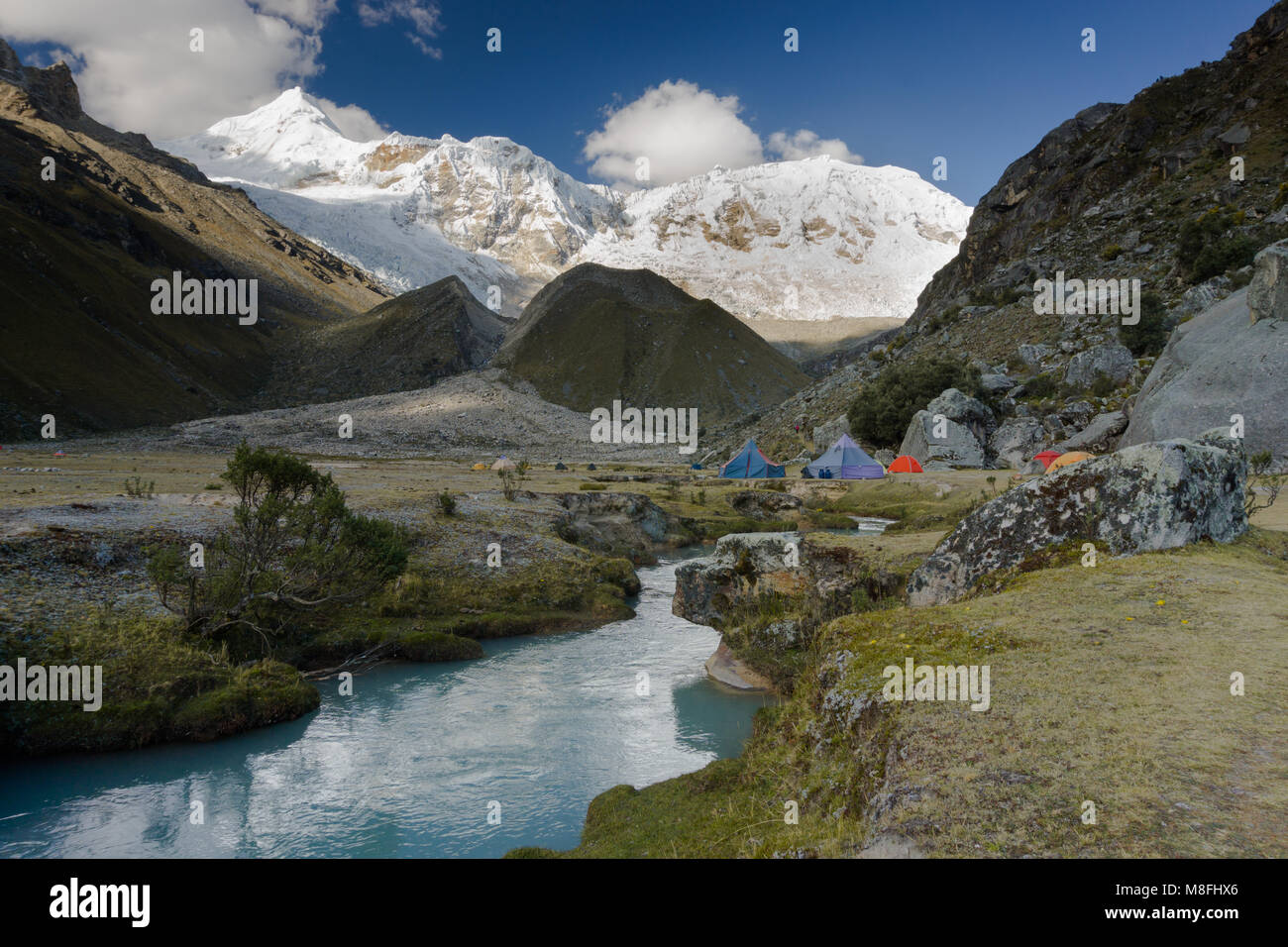 Camping dans le désert à distance des Andes au Pérou avec des montagnes enneigées et un ruisseau de montagne turquoise calme Banque D'Images