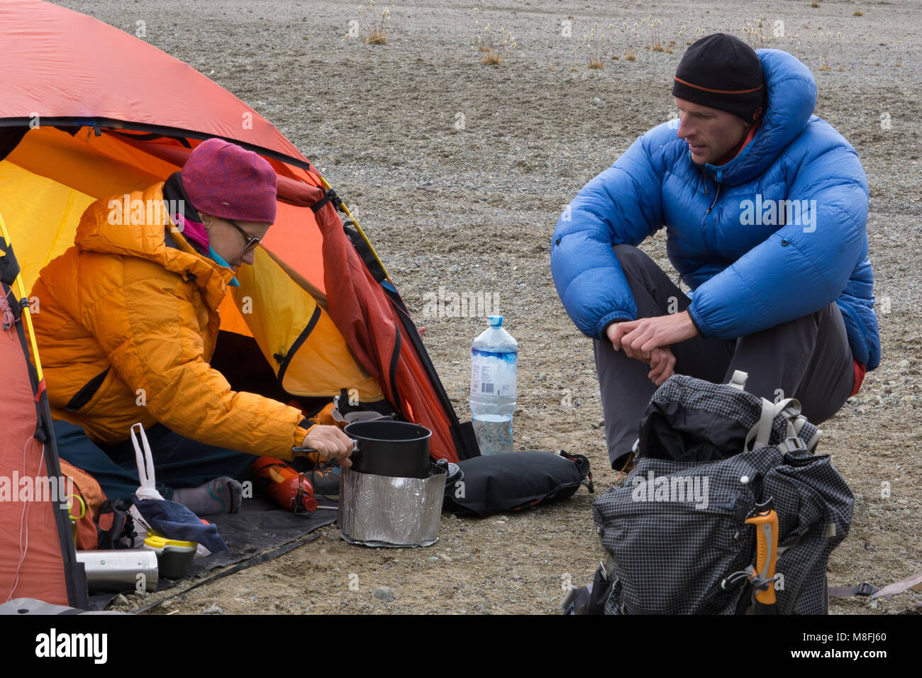 Couple d'alpiniste à la cuisson des aliments et d'un plateau à un camp de base à distance à l'état sauvage Cordillère des Andes au Pérou pendant un trek Banque D'Images Couple d'alpiniste à la cuisson des aliments et d'un plateau à un camp de base à distance à l'état sauvage Cordillère des Andes au Pérou pendant un trek Banque D'Images