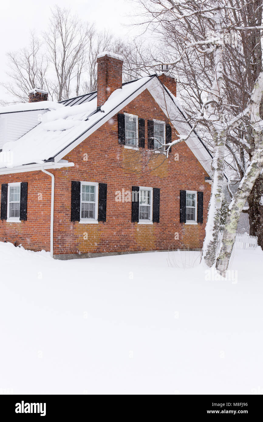 La neige qui tombe autour d'une nouvelle brique classique Angleterre ferme avec picket fence. Banque D'Images