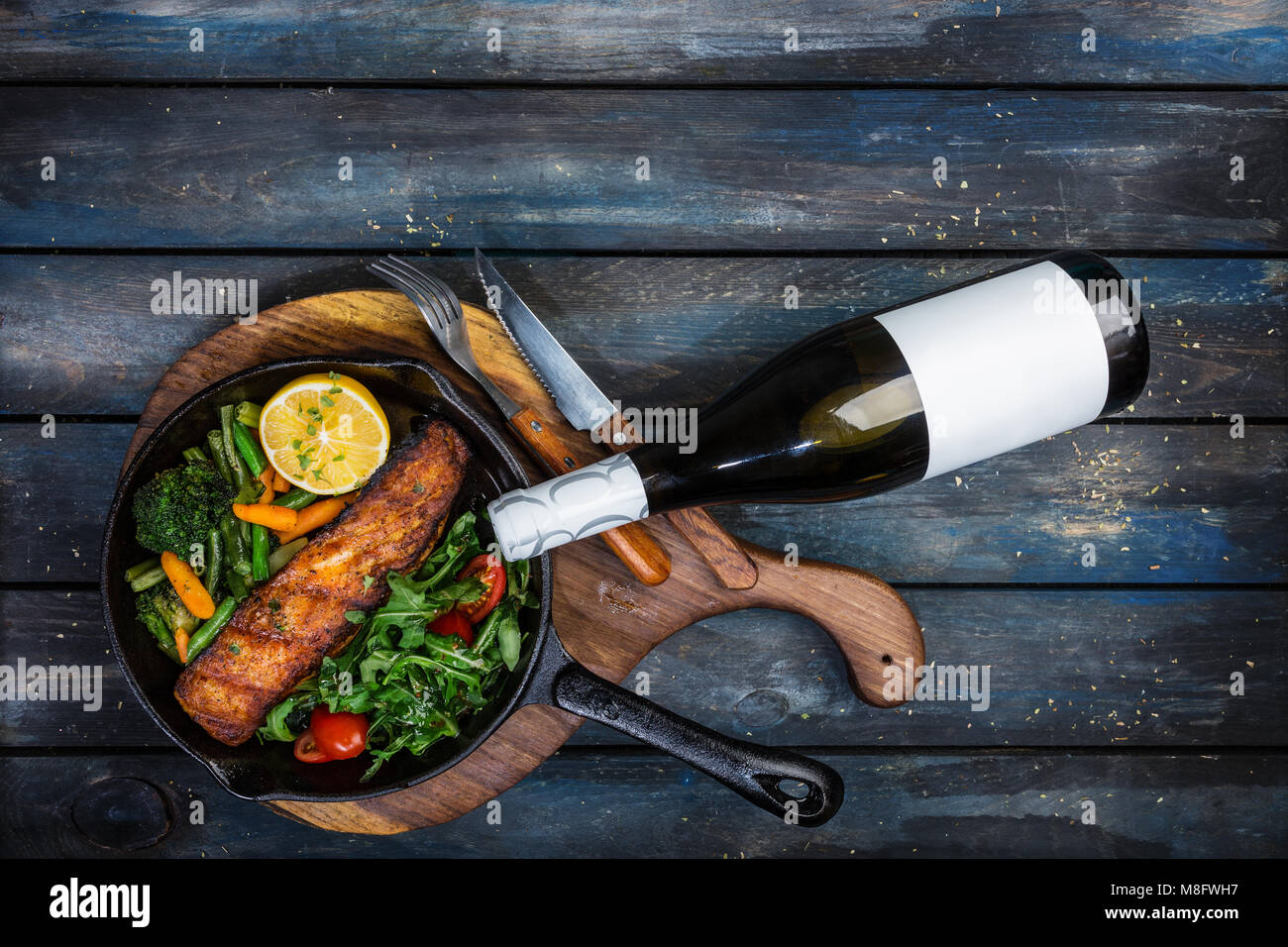 Pavé de saumon grillé dans une poêle, les légumes, la roquette avec un citron. Banque D'Images