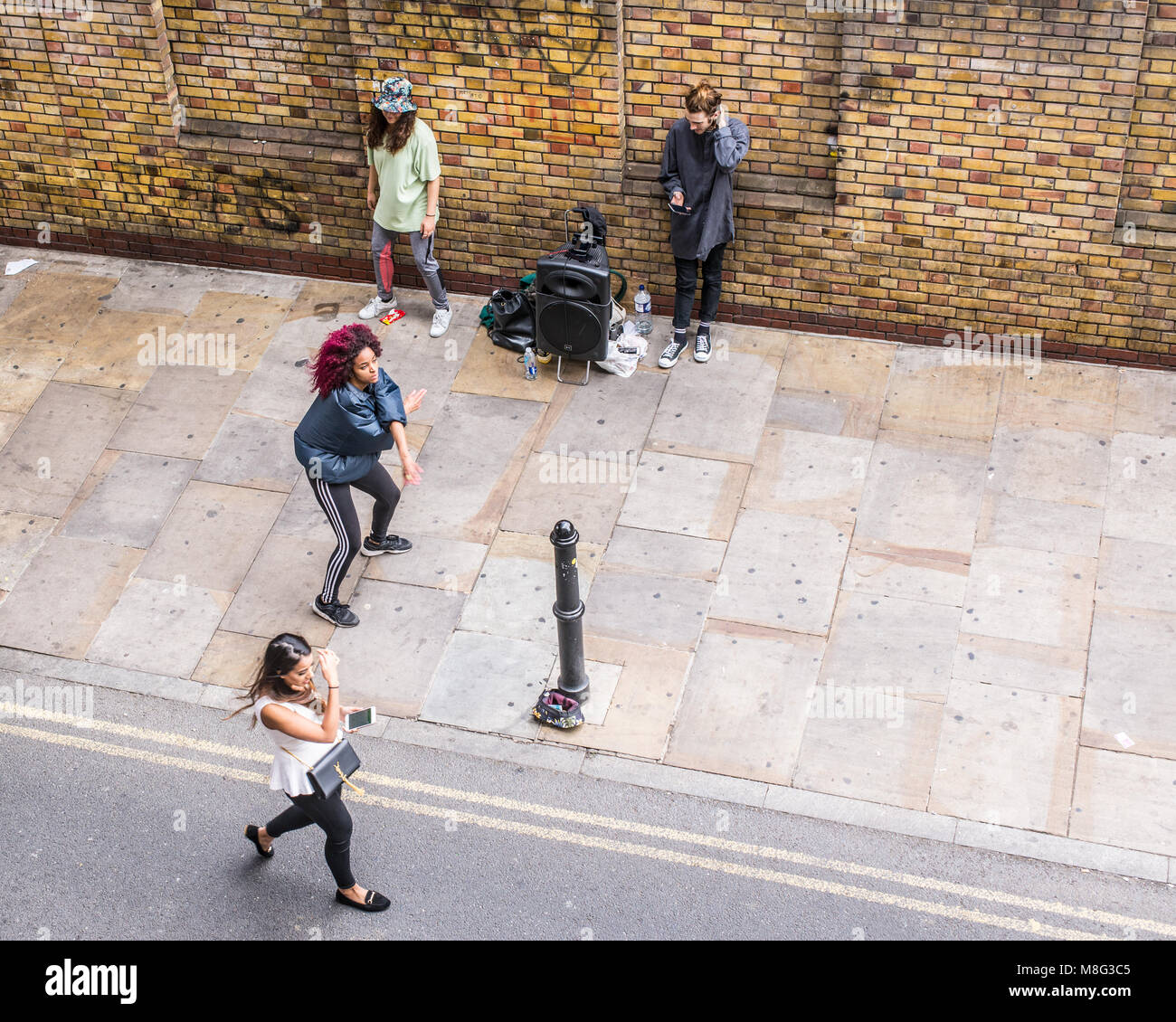 Street dance performance improvisée par le hip-hop danseurs acrobatiques et regarder les gens à l'extérieur de l'Old Truman Brewery, Ely's Yard, Shoreditch, London, U Banque D'Images