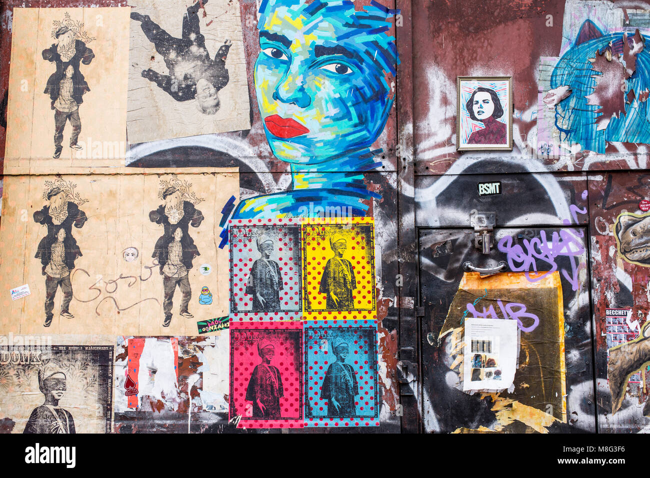 Vieille porte couverts en autocollants et street art peintures murales dans la rue Commerciale, Spitalfields, Shoreditch, East London, UK Banque D'Images