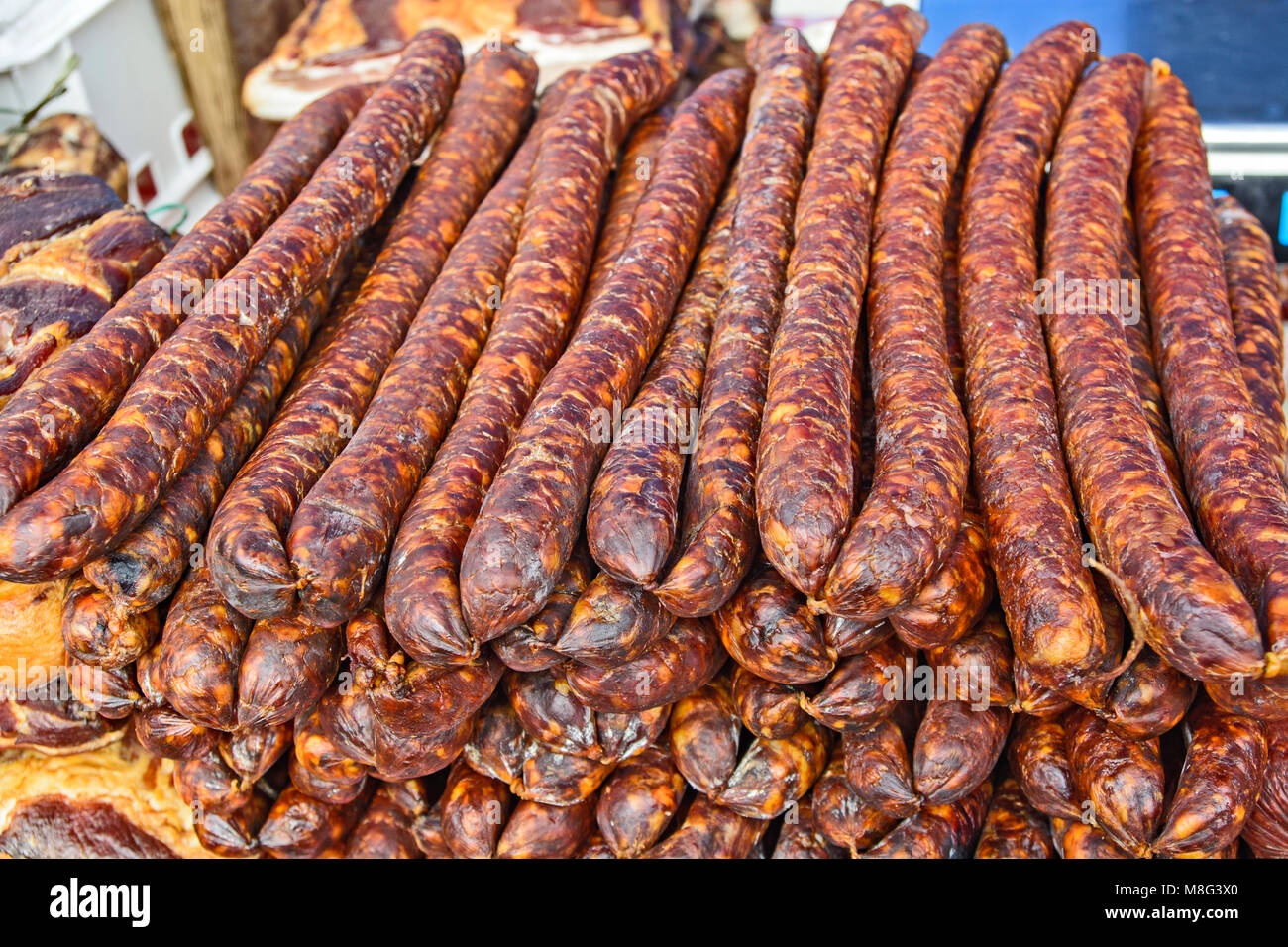 Des saucisses de porc fumé et séché debout sur la table pour la vente. Banque D'Images