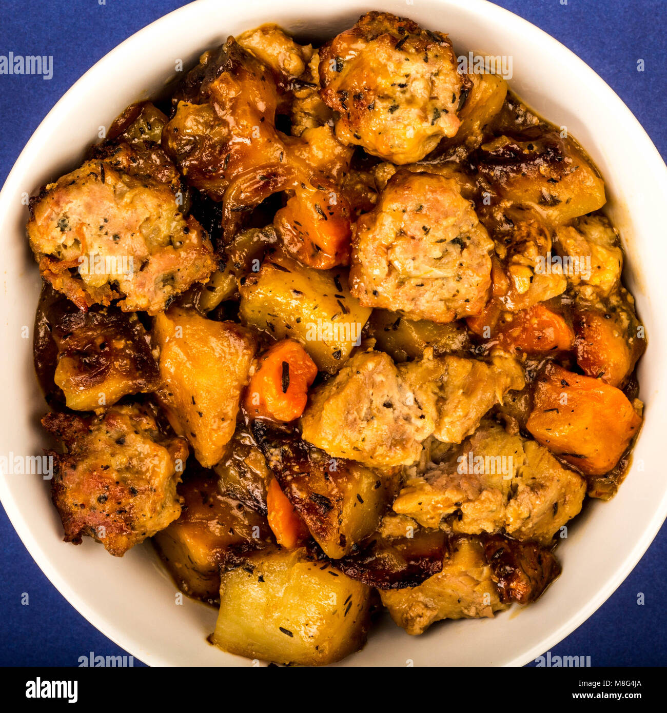 Style anglais britannique ou du porc rôti lentement et de farce en casserole contre un fond bleu foncé Banque D'Images