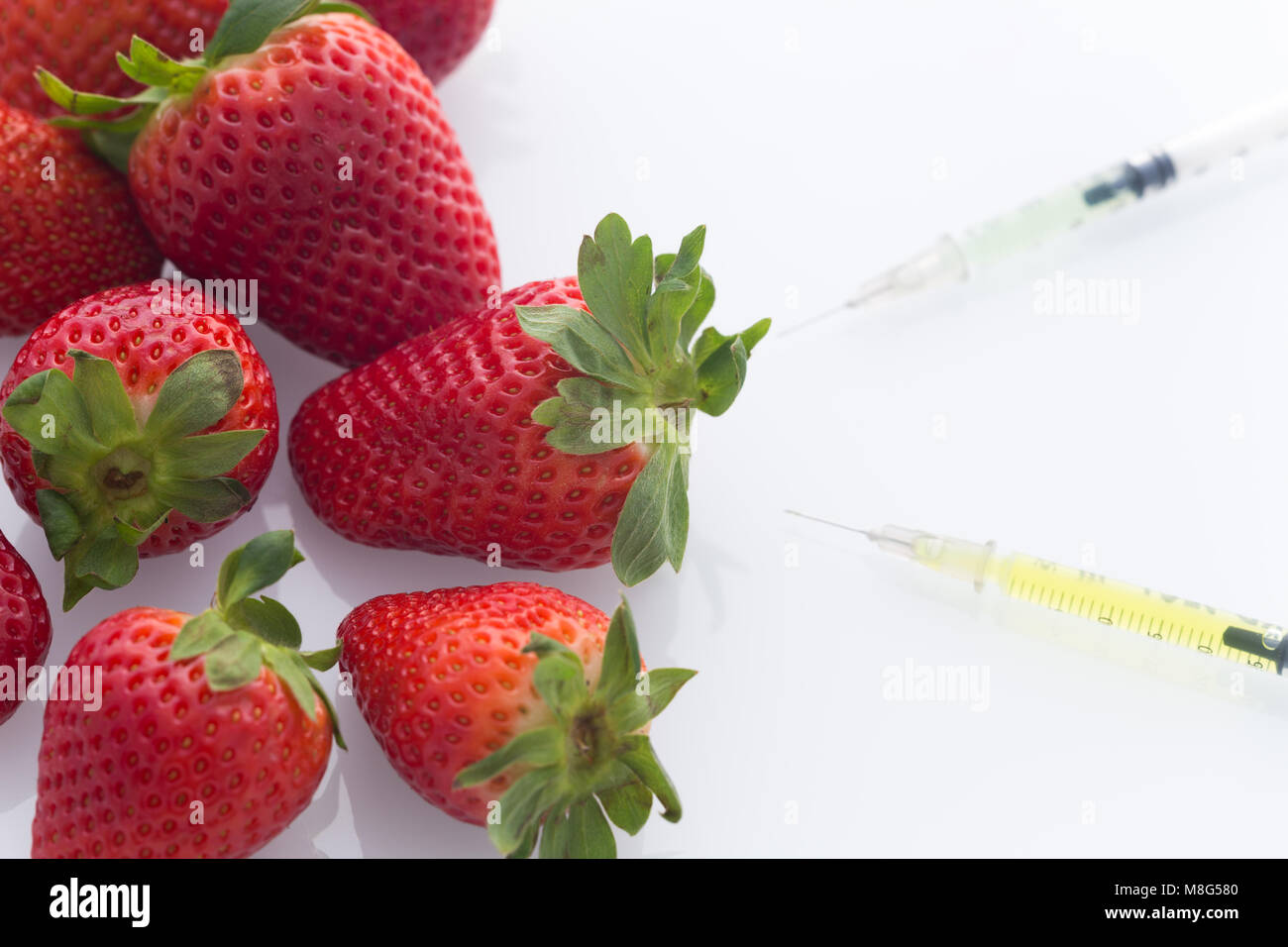 Modifiés concept / fraises avec les aiguilles et seringues perforé Photo  Stock - Alamy