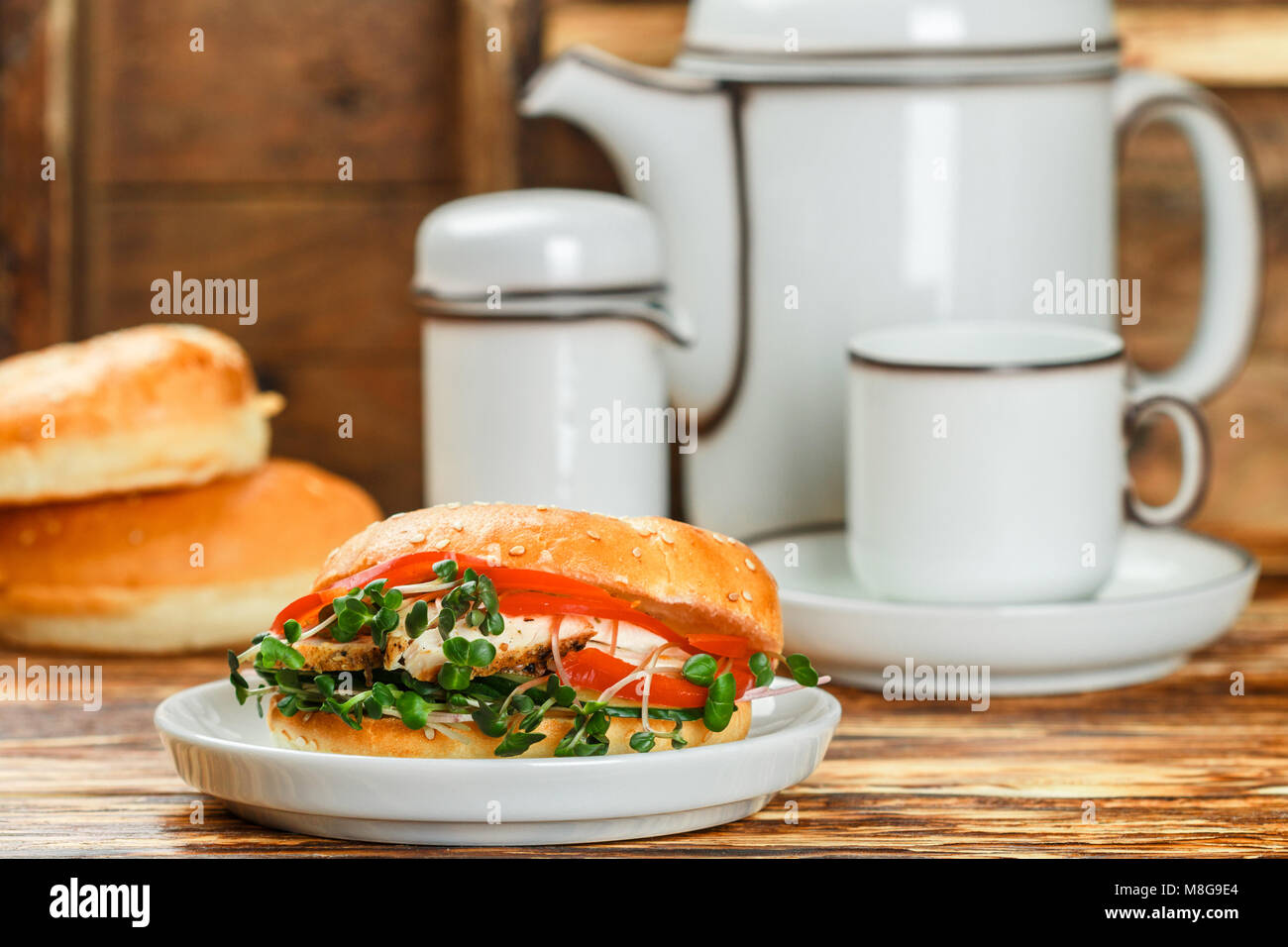 Graines de sésame poulet bagels de grains entiers avec grill, Microgreens, concombre et avocat sur plaque blanche sur fond gris. Petit-déjeuner sain concept . S Banque D'Images
