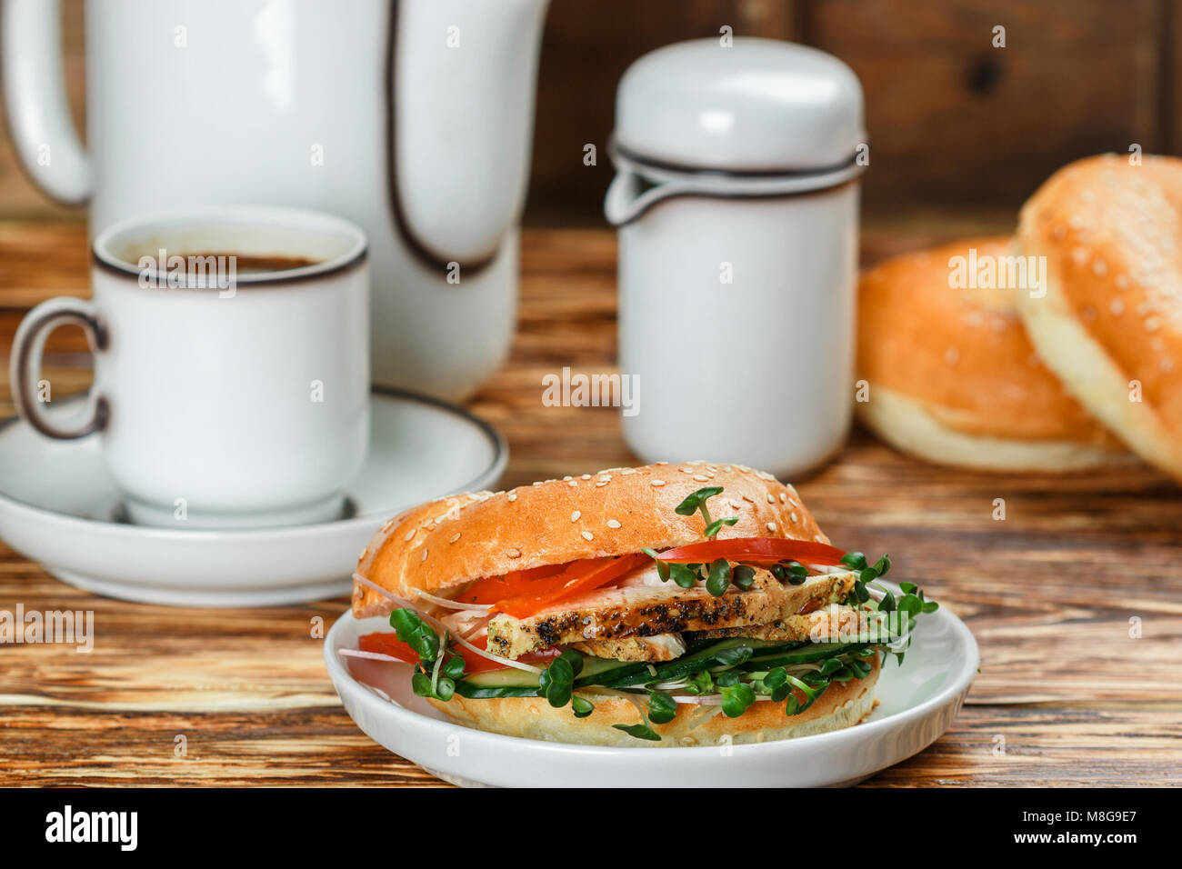 Graines de sésame poulet bagels de grains entiers avec grill, Microgreens, concombre et avocat sur plaque blanche sur fond gris. Petit-déjeuner sain concept . S Banque D'Images