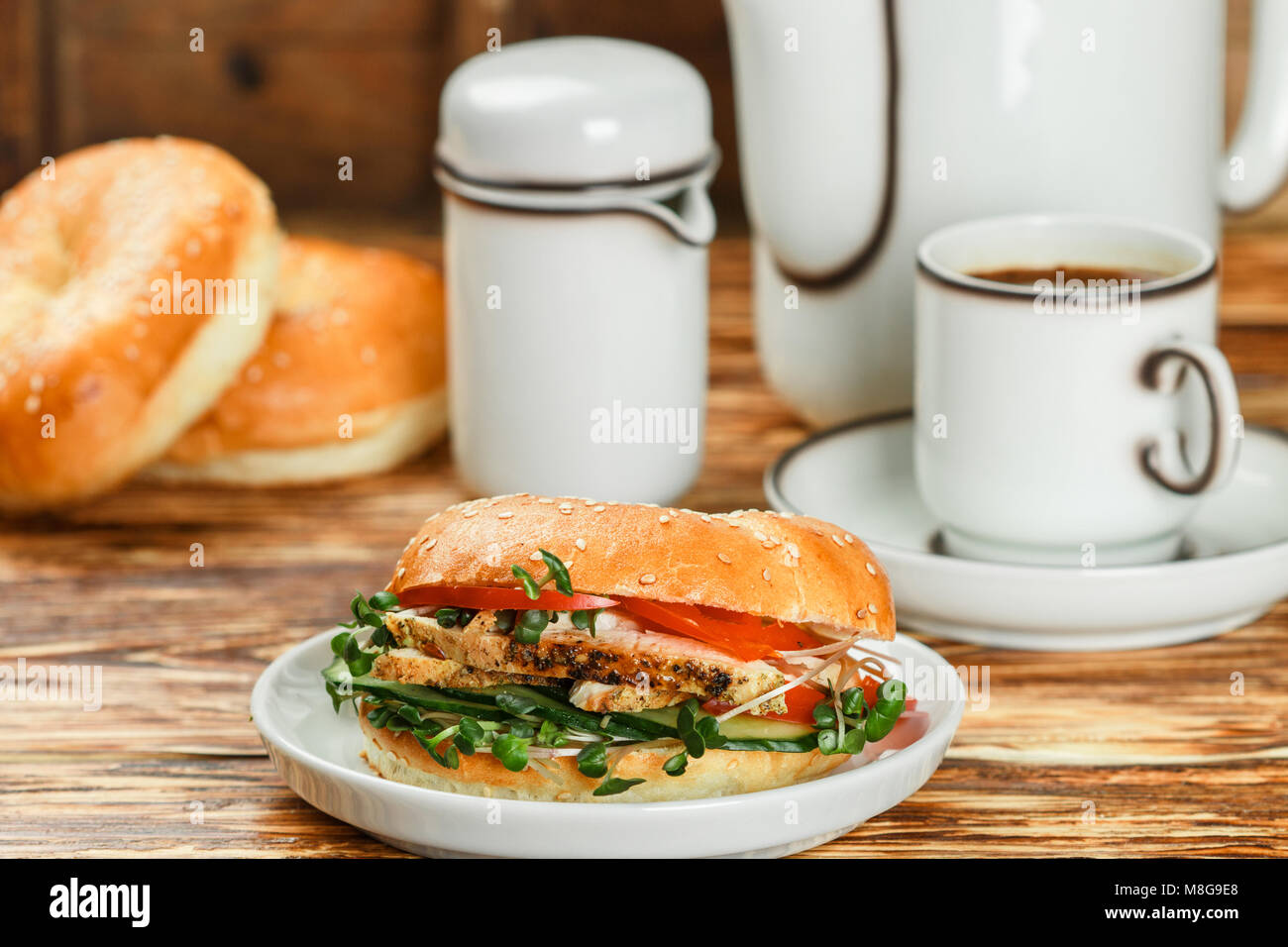 Graines de sésame poulet bagels de grains entiers avec grill, Microgreens, concombre et avocat sur plaque blanche sur fond gris. Petit-déjeuner sain concept . S Banque D'Images