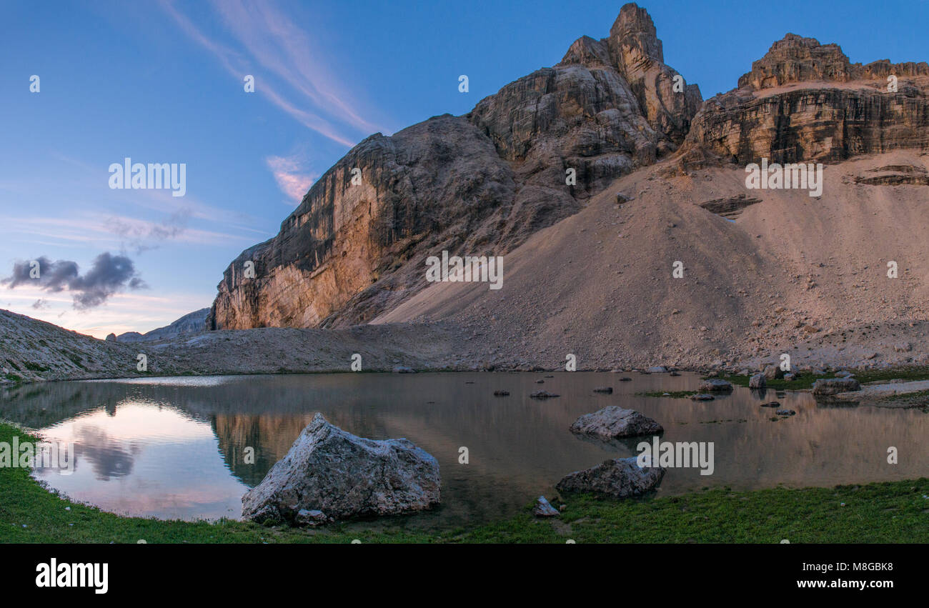 Alpin merveilleux lac, étang reflétant les montagnes alors qu'un ciel peint montre les couleurs chaudes de l'aube. Alpes italiennes, Fanes Senes Braies park. Banque D'Images