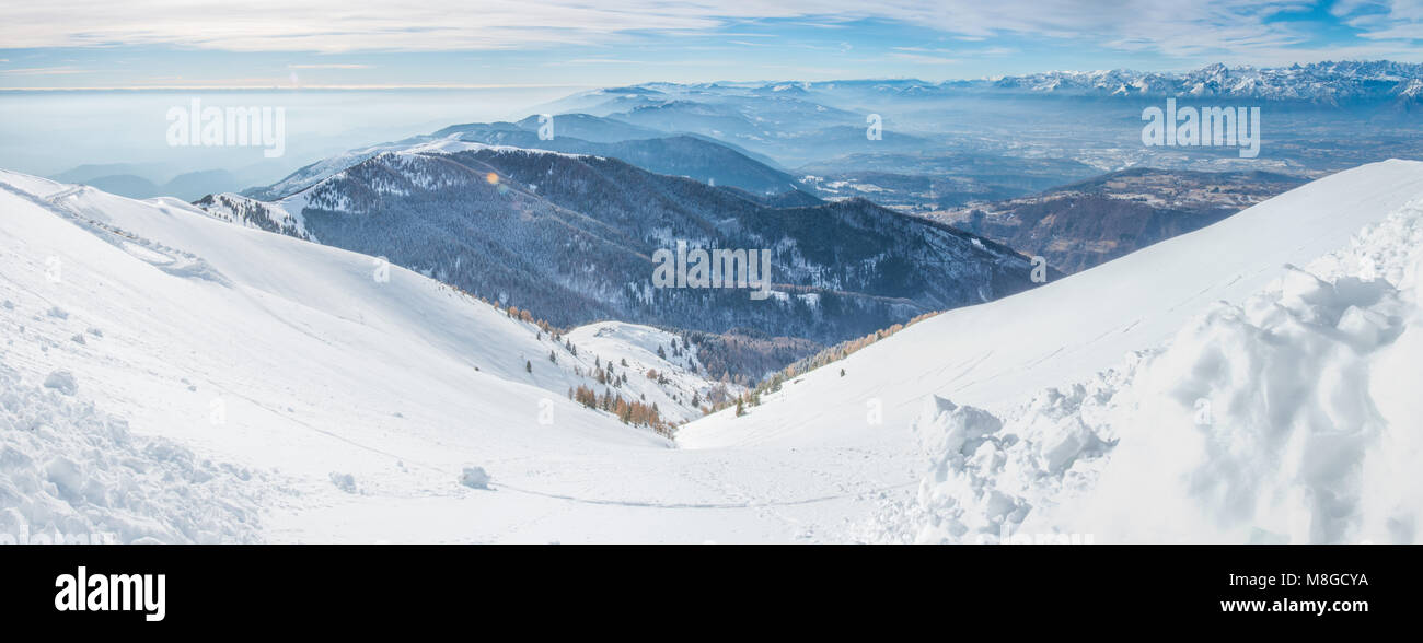 Belle vue sur les Alpes, la neige qui couvre tous les sommets, quittant la vallée et de la ville dans une fine brume. Snowy Woods, l'hiver la raquette. Banque D'Images