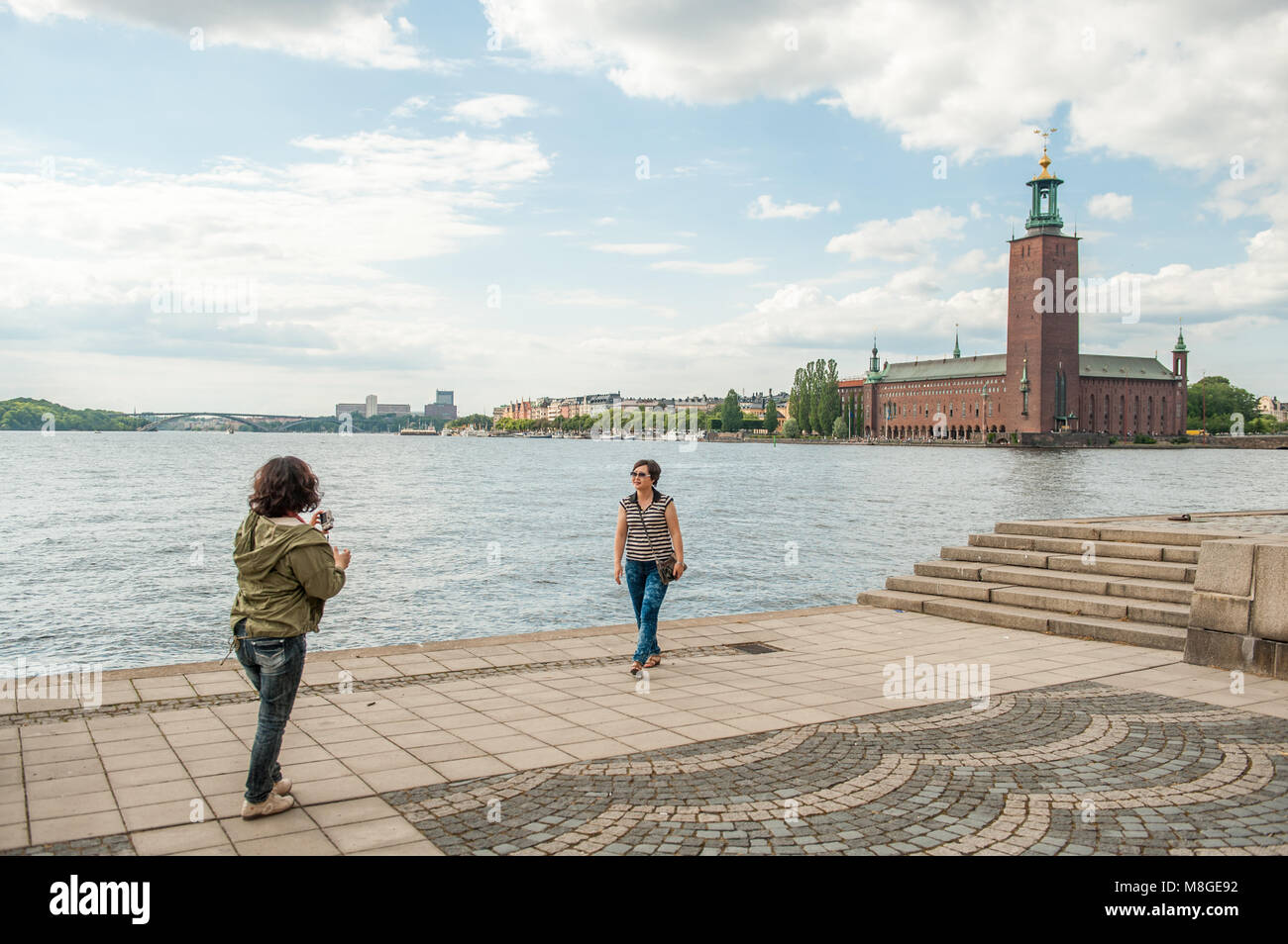 Les touristes profiter de la vue de Riddarholmen vers l'Hôtel de Ville de Stockholm. Ce bâtiment emblématique est le lieu de la réception du prix Nobel. Banque D'Images