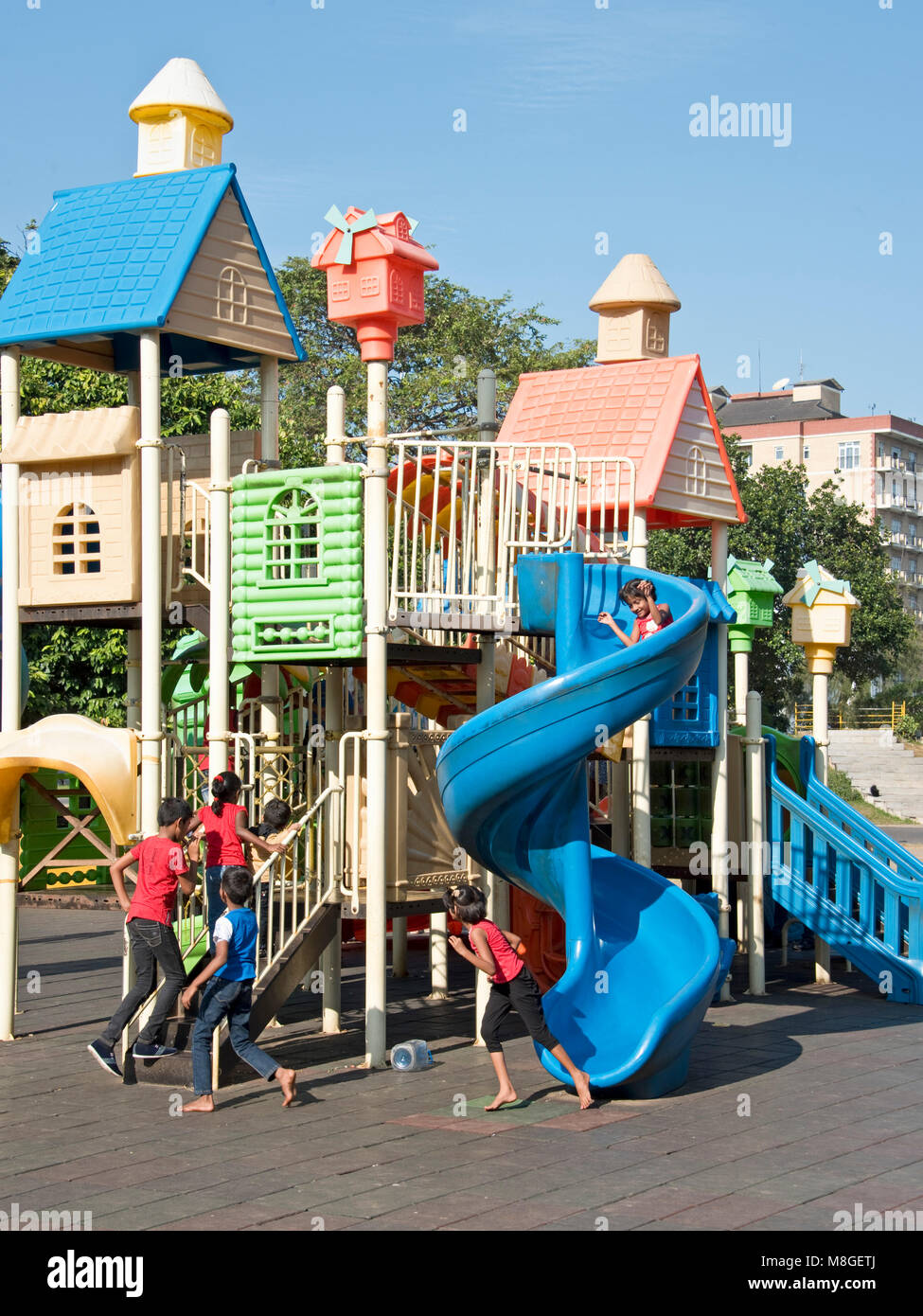 Enfants jouant dans l'aire de jeux de Viharamahadevi Park (Vihara maha devi) sur une journée ensoleillée avec ciel bleu. Banque D'Images