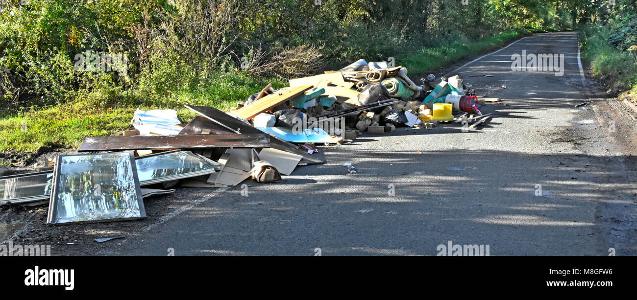 Les décharges sauvages de déchets divers, d'un camion à ordures détritus abandonnés sur la voie publique dans un pays lane Brentwood Navestock campagne de l'Essex England UK Banque D'Images
