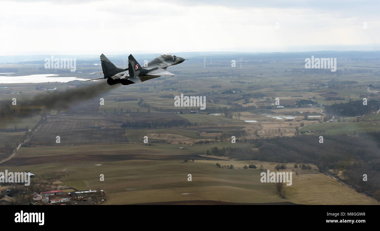 Une armée de l'Air polonaise MiG-29 accélère et monte pendant un vol en formation avec un U.S. Air Force C-130 Hercules de la 182e Escadre de transport aérien dans le nord de la Pologne, le 15 mars 2018. Environ 70 aviateurs et trois C-130 à partir de la 182e Escadre de transport aérien participent à la formation bilatérale avec l'Armée de l'Air polonaise pendant la rotation de l'Aviation 18-2 dans le cadre de l'opération Atlantic résoudre. Ces événements se produisent à travers les États-Unis en Europe domaine de responsabilité et sont conçus pour améliorer l'interopérabilité partenaire, maintenir l'état de préparation conjointe, et assurer à nos alliés régionaux. (U.S. Air National G Banque D'Images