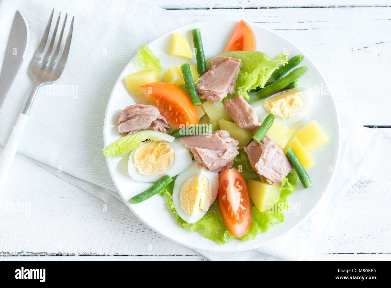 Salade niçoise au thon, oeufs, pommes de terre, haricots verts et tomates. Salade niçoise traditionnelle bleu sur fond de bois, vue du dessus, copiez l'espace. Banque D'Images